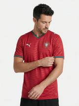 Man wearing a red sports jersey with a logo on a white background