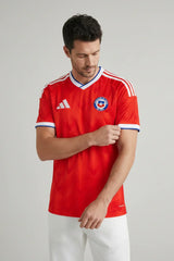 Person wearing a red sports jersey with a logo on a gray background