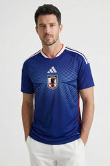 Man wearing a blue sports jersey with a logo on a white background