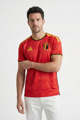 Man wearing a red sports jersey with yellow accents on a white background