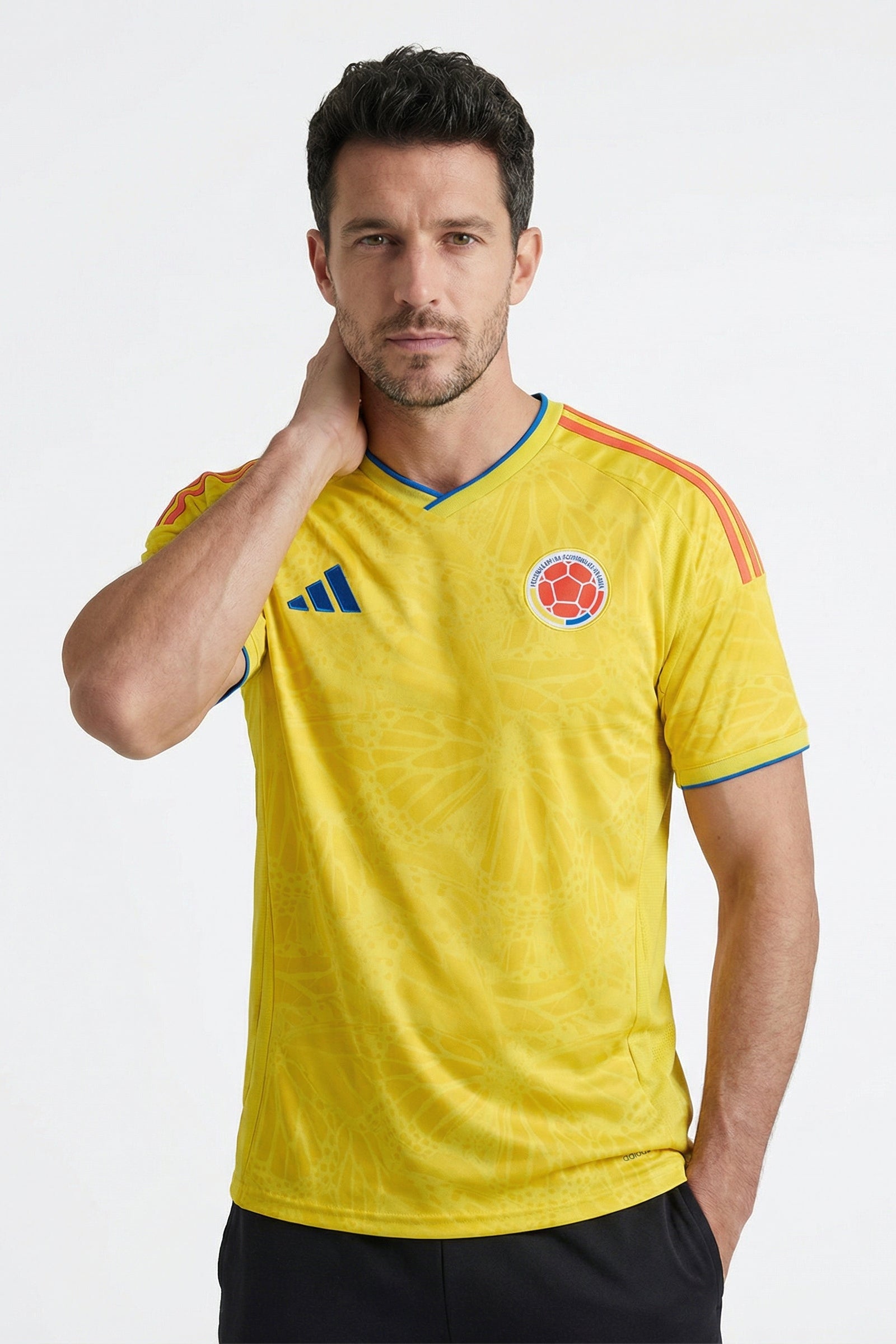 Man wearing a yellow sports jersey with a logo on a white background