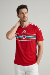 Man wearing a red sports jersey with a logo on a gray background