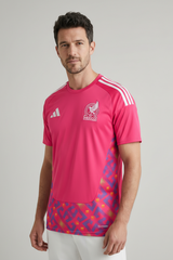 Man wearing a pink sports jersey with Adidas logo on a gray background