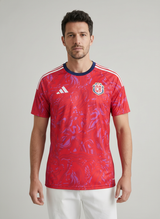 Man wearing a red sports jersey with Adidas logo on a gray background